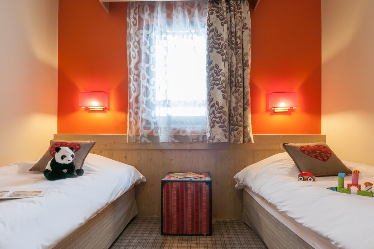 A bedroom with two beds and a toy car on the floor