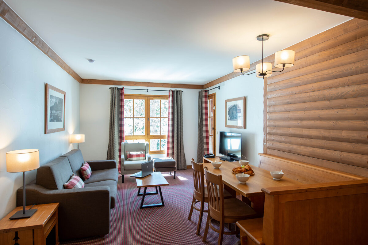 A living room with a couch table and chairs