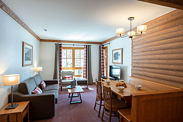 A living room with a couch table and chairs