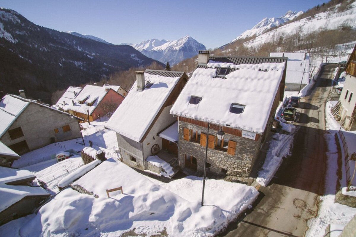 An aerial view of a snowy village with mountains in the background