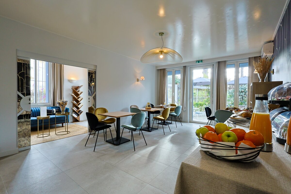 A bowl of fruit sits on a table in a dining room
