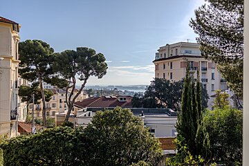 A view of a city with a few buildings and trees in the foreground