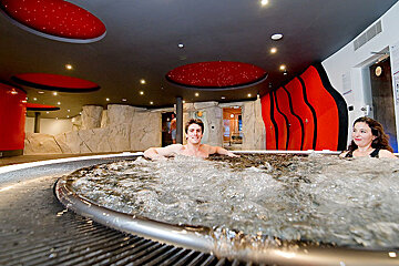 A man and a woman are sitting in a hot tub