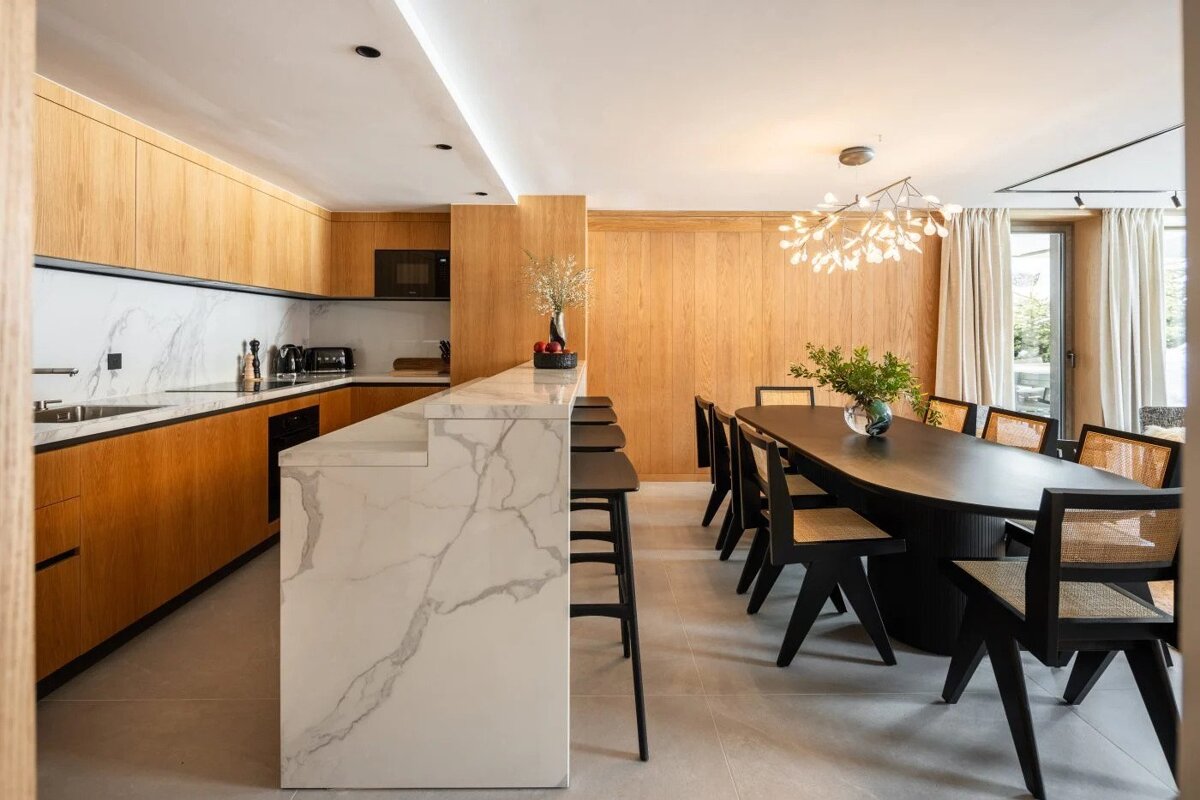 A kitchen with marble counter tops and wooden cabinets