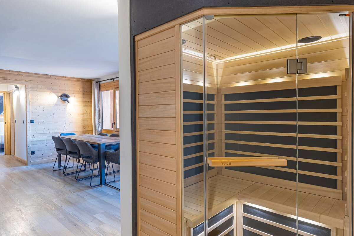 A wooden sauna with a glass door and a wooden handle