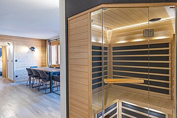 A wooden sauna with a glass door and a wooden handle