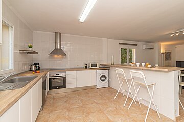 A kitchen with white cabinets and a washing machine