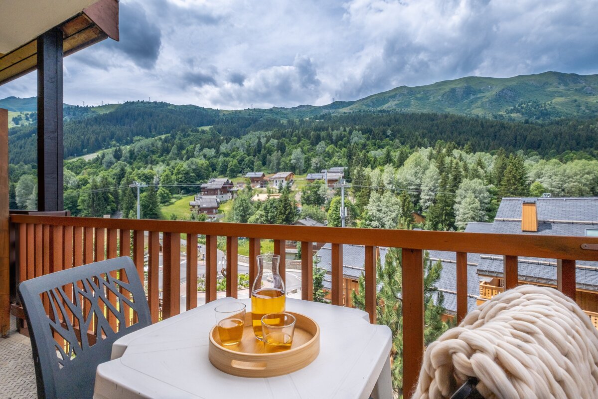 A balcony with a view of mountains and houses
