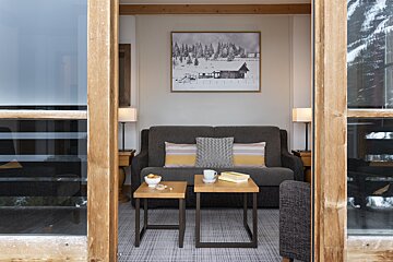 A living room with a couch and a picture on the wall