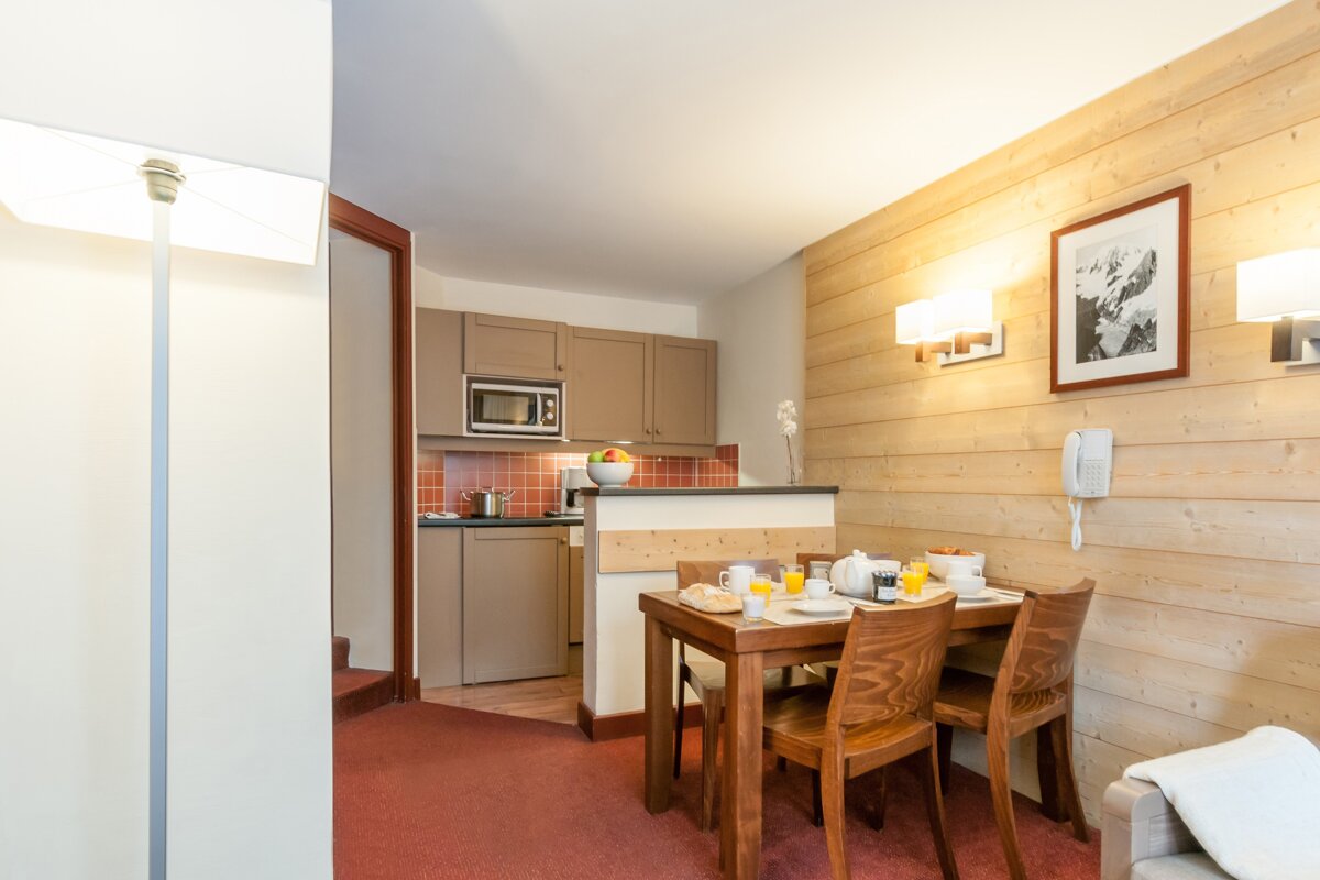A kitchen with a table and chairs and a microwave