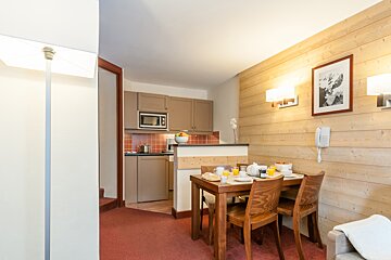 A kitchen with a table and chairs and a microwave