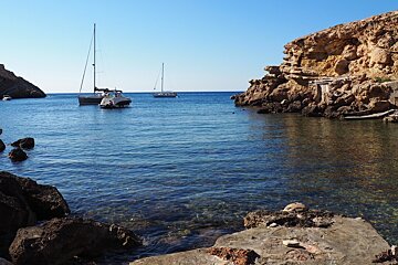a view from the beach in cala yoga of the yachts int he water