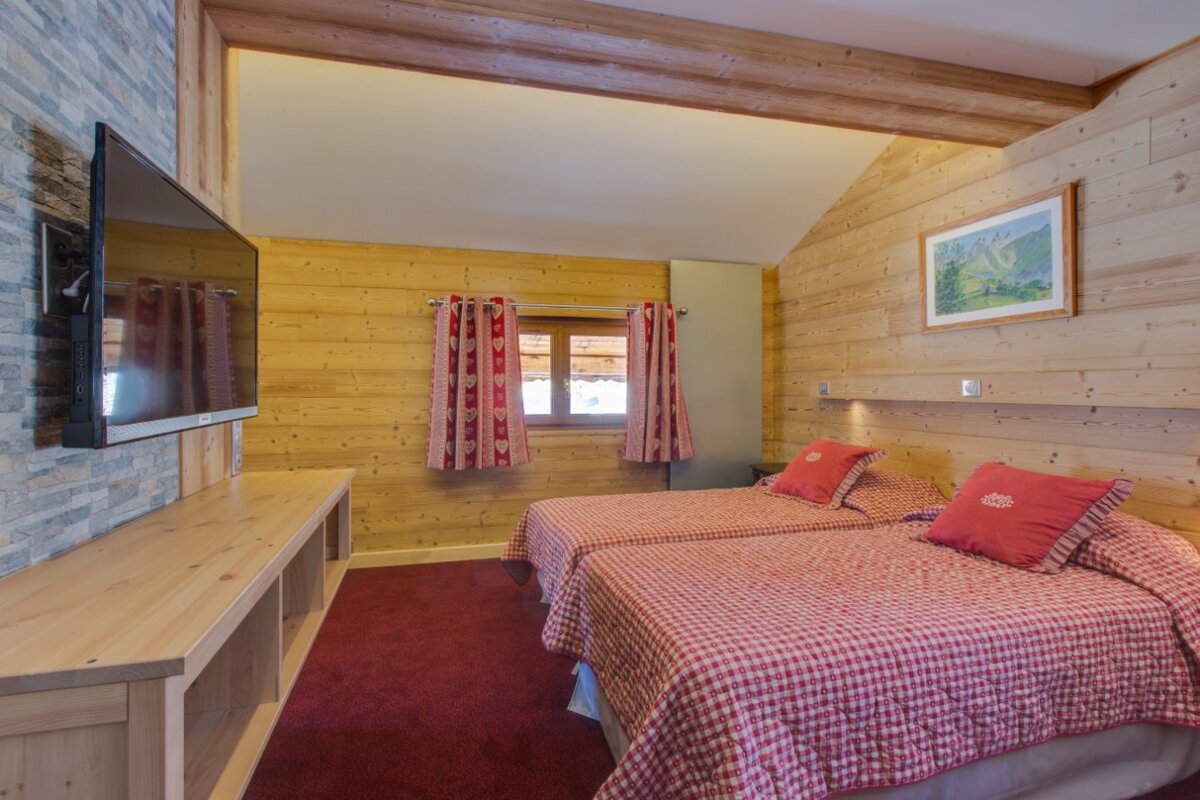 A bedroom with two beds and a flat screen tv