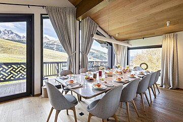A dining room with a long table and chairs