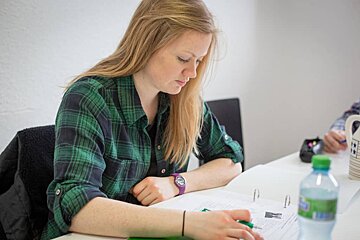 A woman wearing a purple watch sitting at a desk