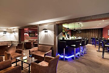A room with a bar and a lot of chairs