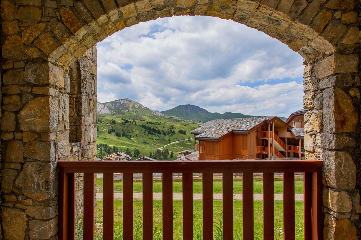 A view of a mountain through a stone archway