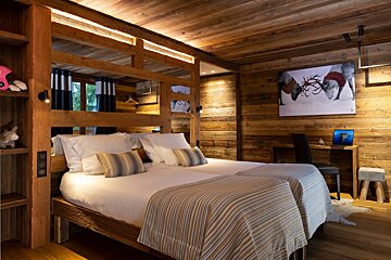 A bedroom with two beds and a picture of reindeer on the wall