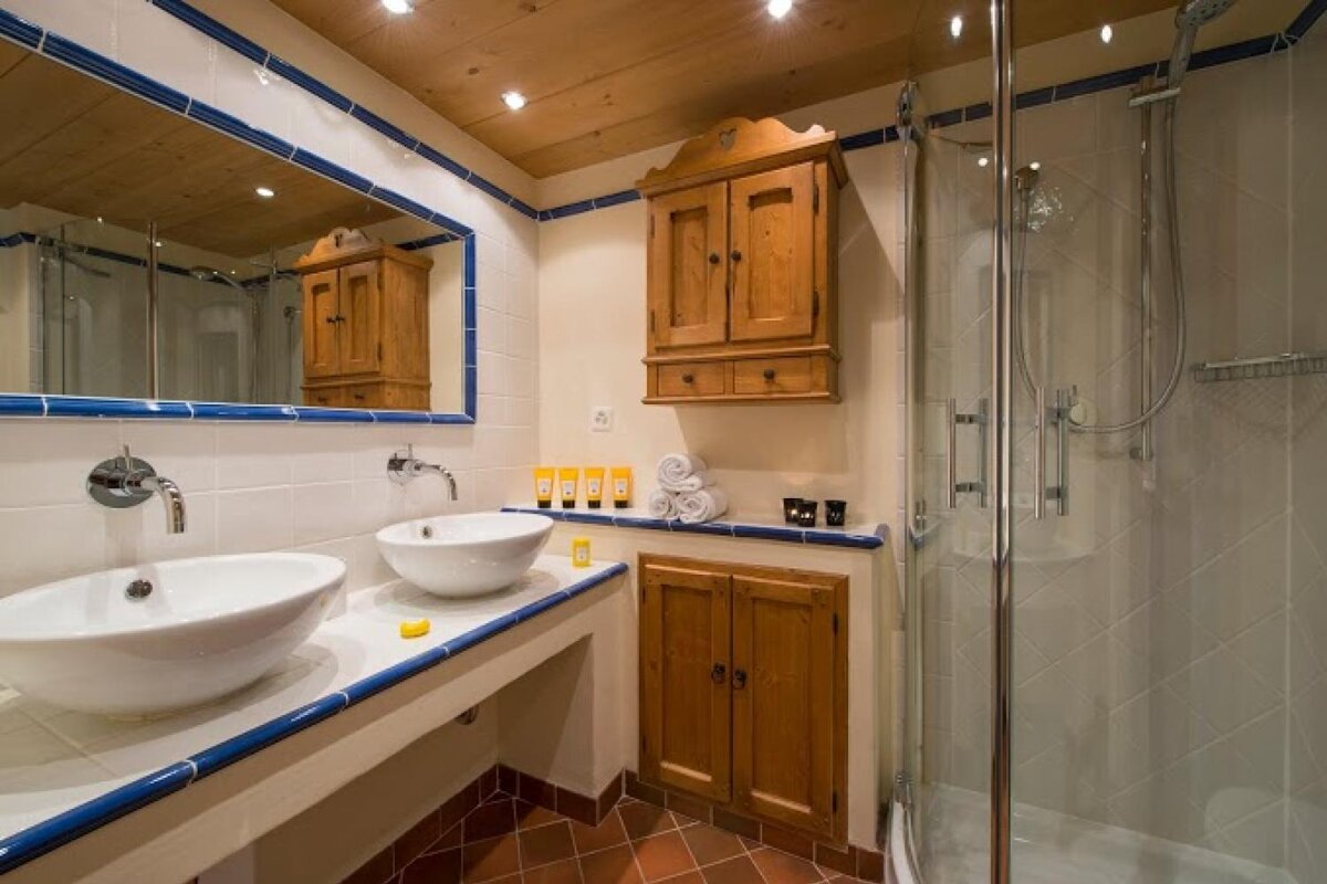 A bathroom with two sinks a mirror and a shower