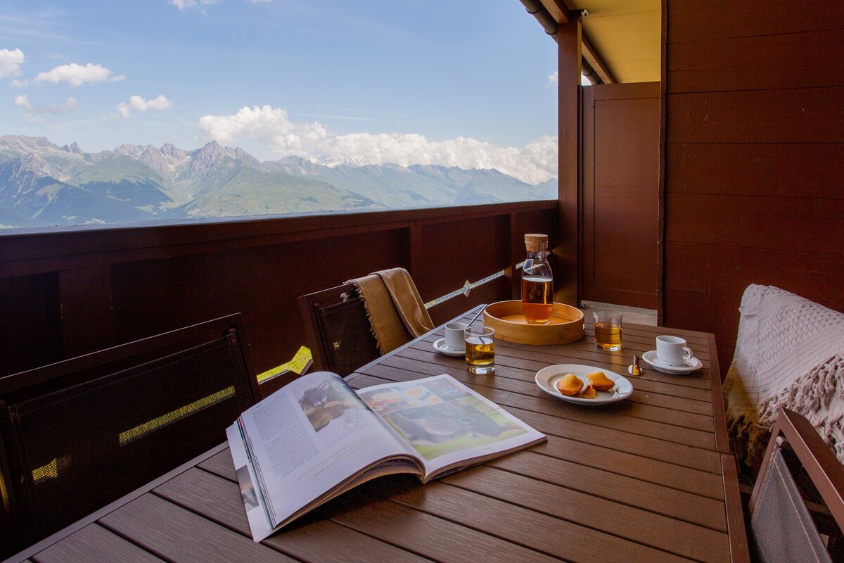 A book is open on a table with a view of the mountains