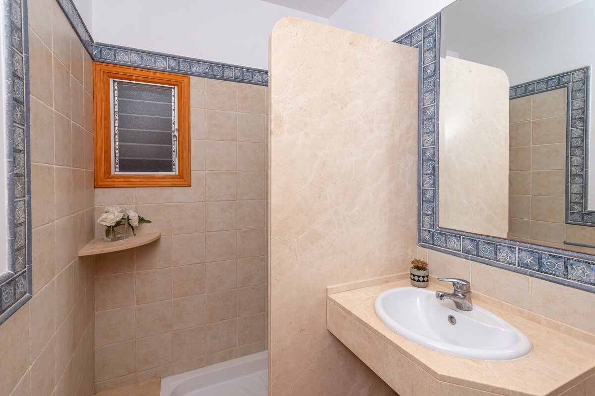 A bathroom with a sink a mirror and a window