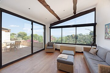 A living room with a couch and chairs and a large window