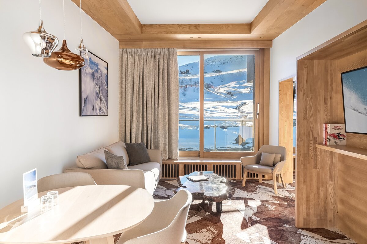 A living room with a couch and chairs and a book on the shelf that says 