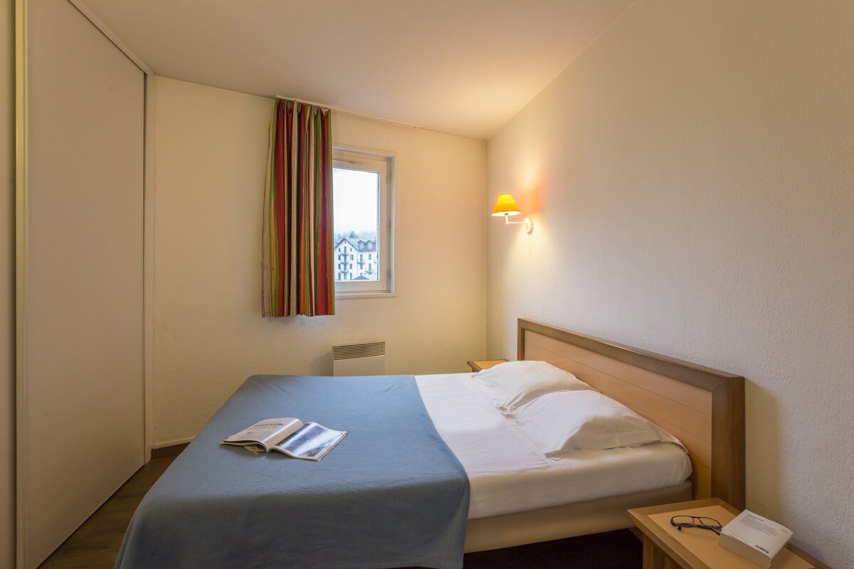 A bedroom with a bed and a book on it