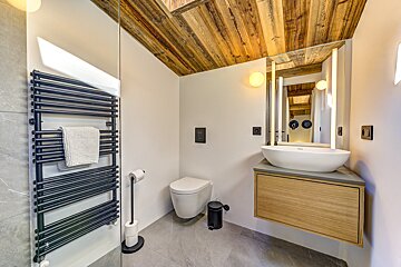A bathroom with a toilet a sink and a towel rack