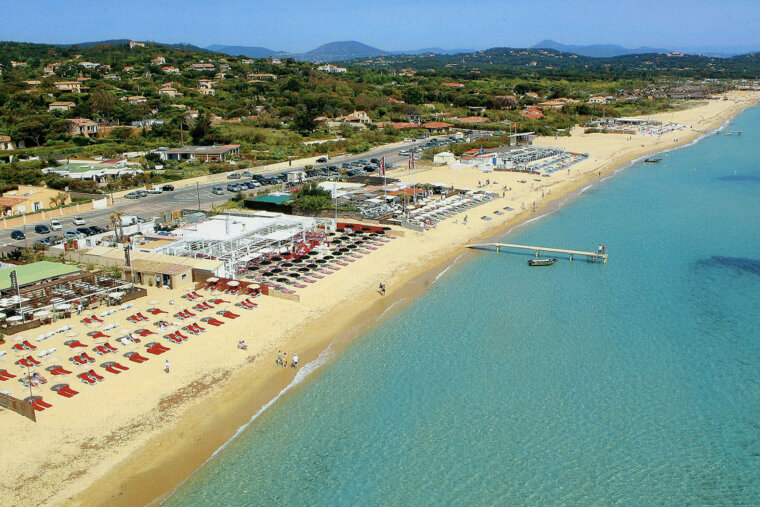 a strip of beach with beach clubs on it
