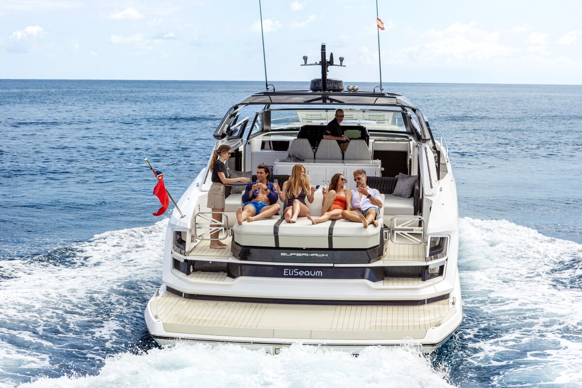 A group of people are sitting on the back of a yacht called eliseoum