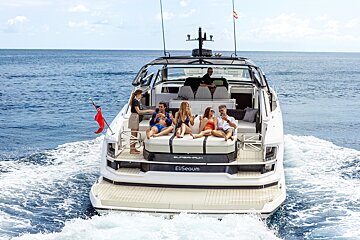 A group of people are sitting on the back of a yacht called eliseoum