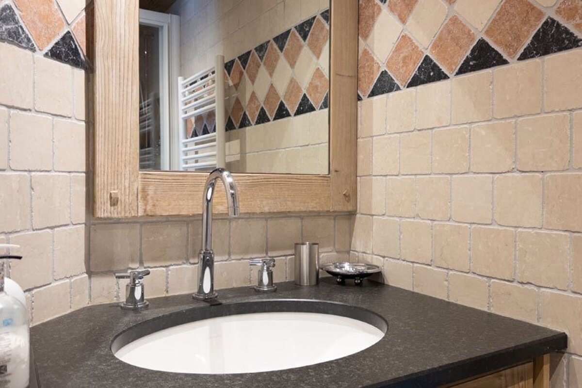 A bathroom sink with a soap dispenser and a mirror