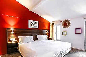 A hotel room with a large bed and red walls