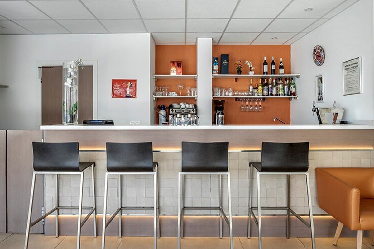 A bar with stools and a sign that says stella artois