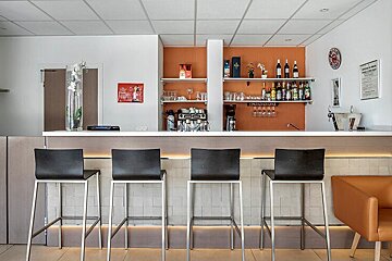 A bar with stools and a sign that says stella artois