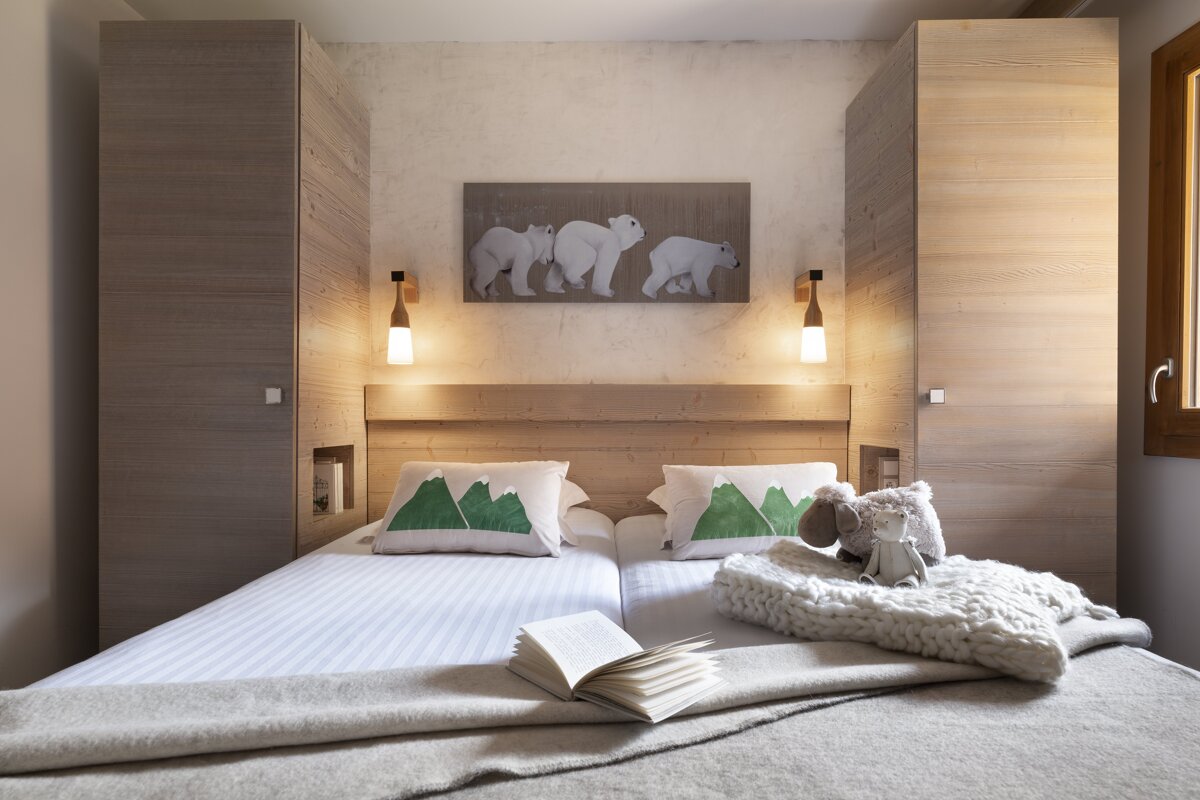 A bedroom with two beds and a painting of polar bears on the wall