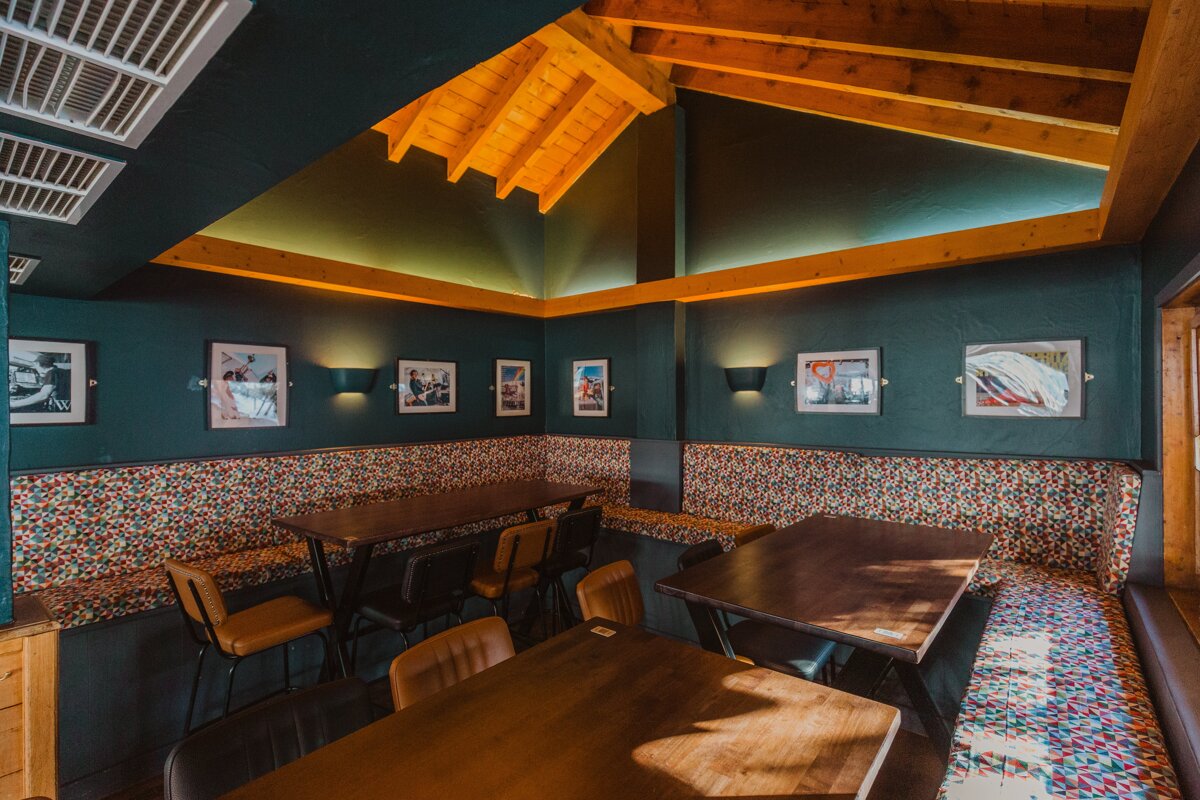 A room with tables and chairs and pictures on the wall