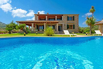 A large house with a swimming pool in front of it