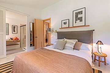 A bedroom with a bed and two framed pictures on the wall