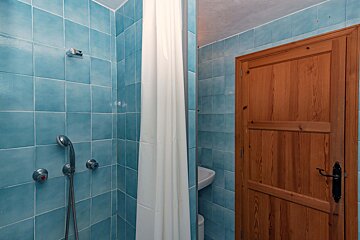 A bathroom with blue tiles and a wooden door