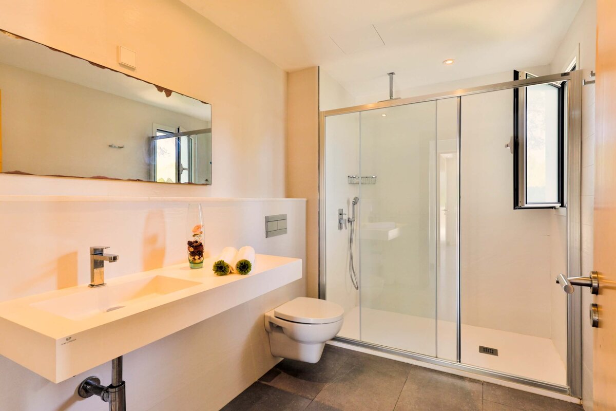 A bathroom with a toilet a sink and a mirror