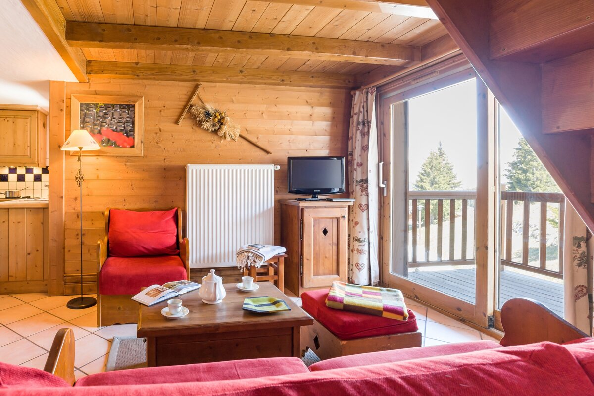 A living room with a red couch and a flat screen tv