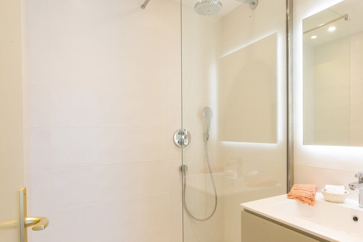 A bathroom with a shower and a mirror
