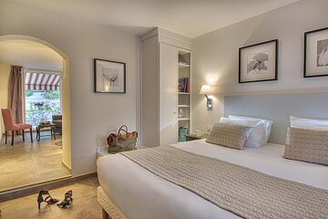 A hotel room with a king size bed and two shoes on the floor