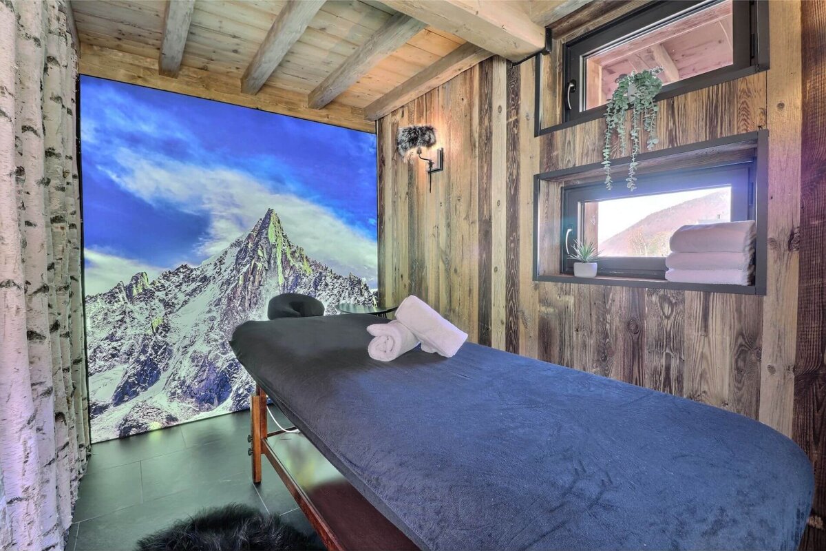 A massage table in a room with a picture of a mountain on the wall