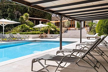 A swimming pool with chairs and umbrellas around it