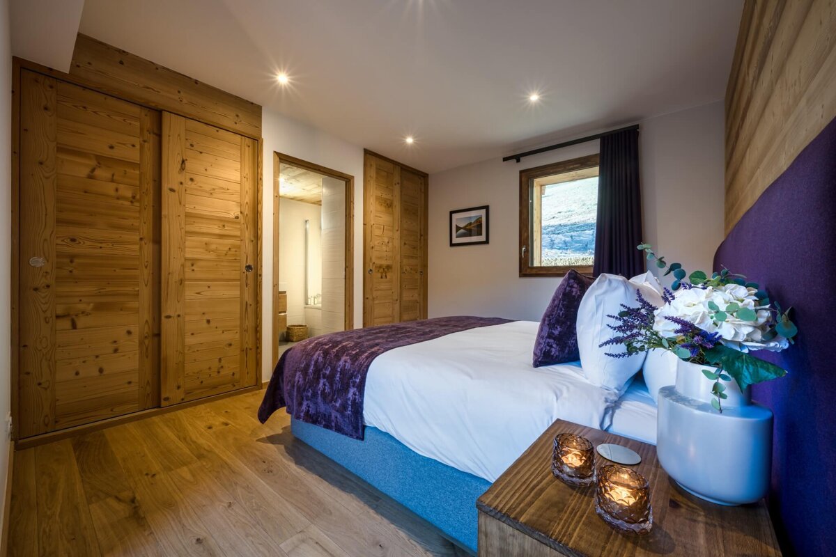 A bedroom with a large bed and a purple headboard