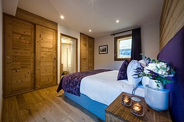 A bedroom with a large bed and a purple headboard