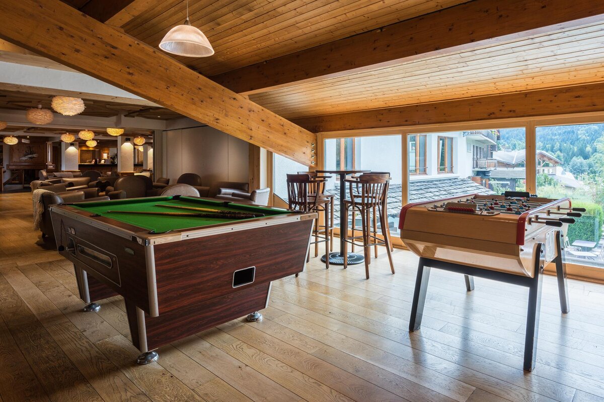 A game room with a pool table and a foosball table
